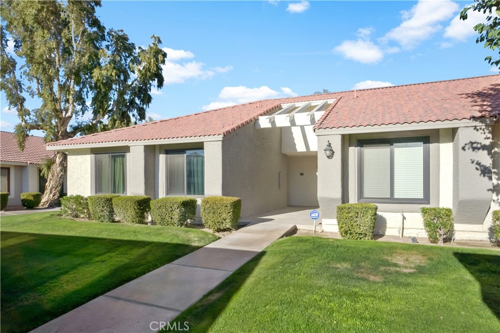 43376 Cook Street, Unit 125 Palm Desert, CA 92211 - Photo 2 of 45 a front view of a house with a yard