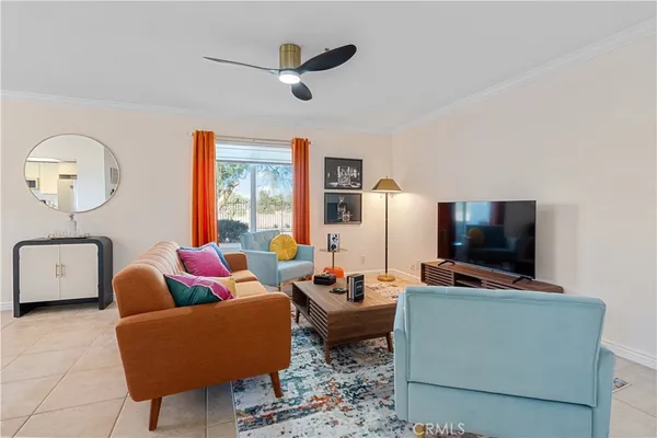 a living room with furniture a flat screen tv and a floor to ceiling window
