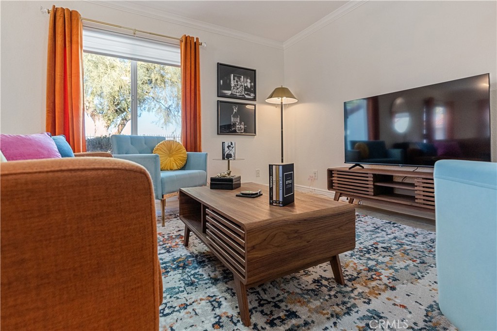 43376 Cook Street, Unit 125 Palm Desert, CA 92211 - Photo 36 of 45 a living room with furniture a flat screen tv and a floor to ceiling window