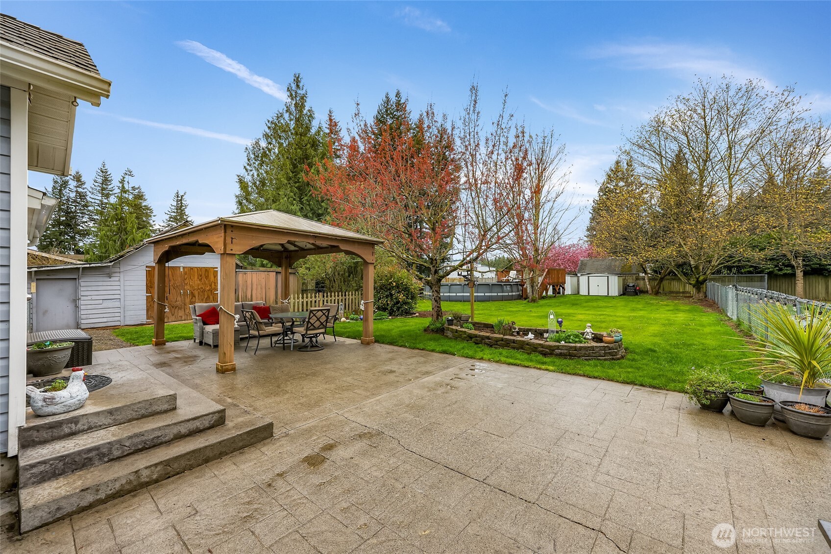6981 Hannegan Road Lynden, WA 98264 - Photo 20 of 25 a view of a park with plants and a table and chairs under an umbrella