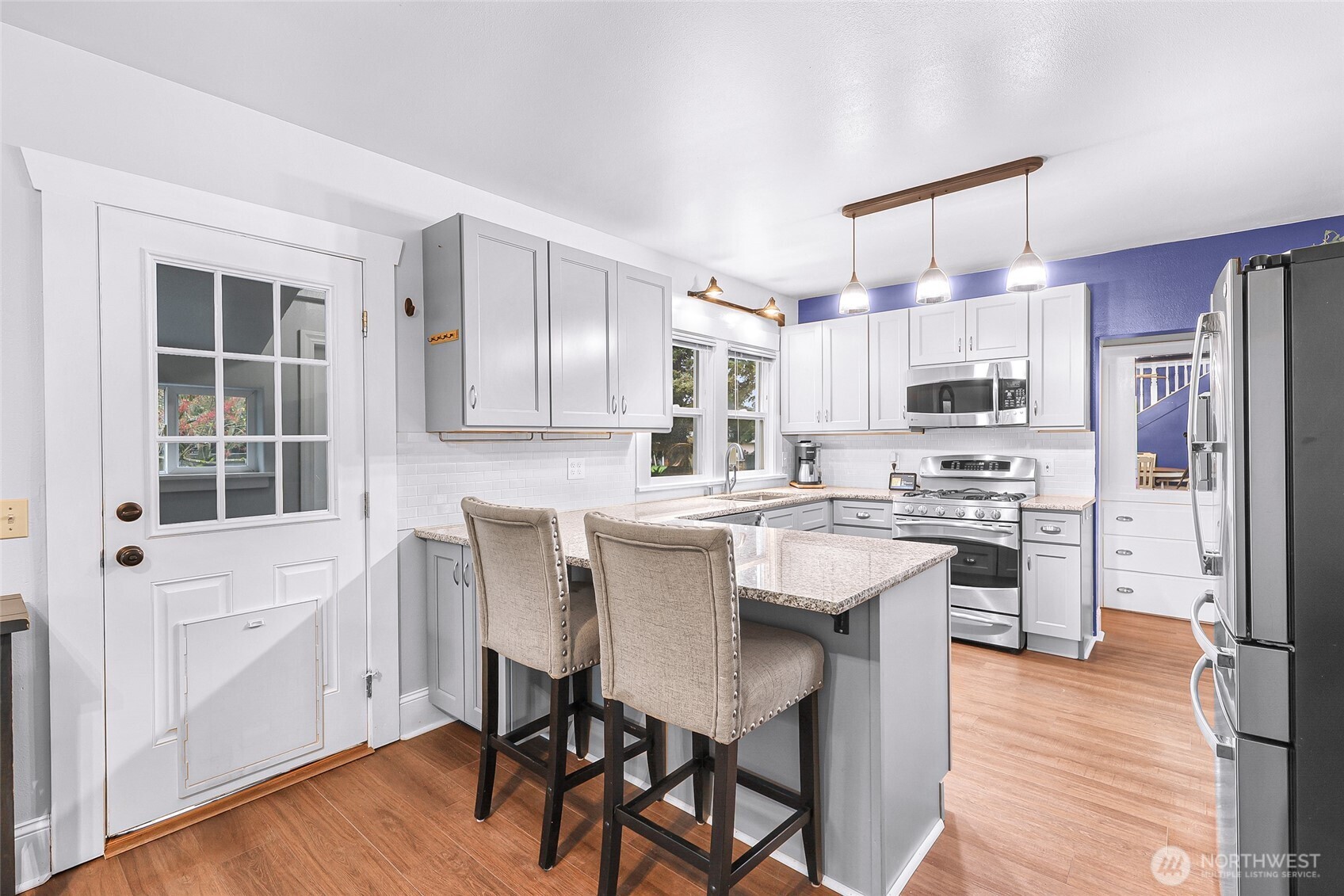 6981 Hannegan Road Lynden, WA 98264 - Photo 10 of 25 a kitchen with stainless steel appliances a dining table chairs refrigerator and sink