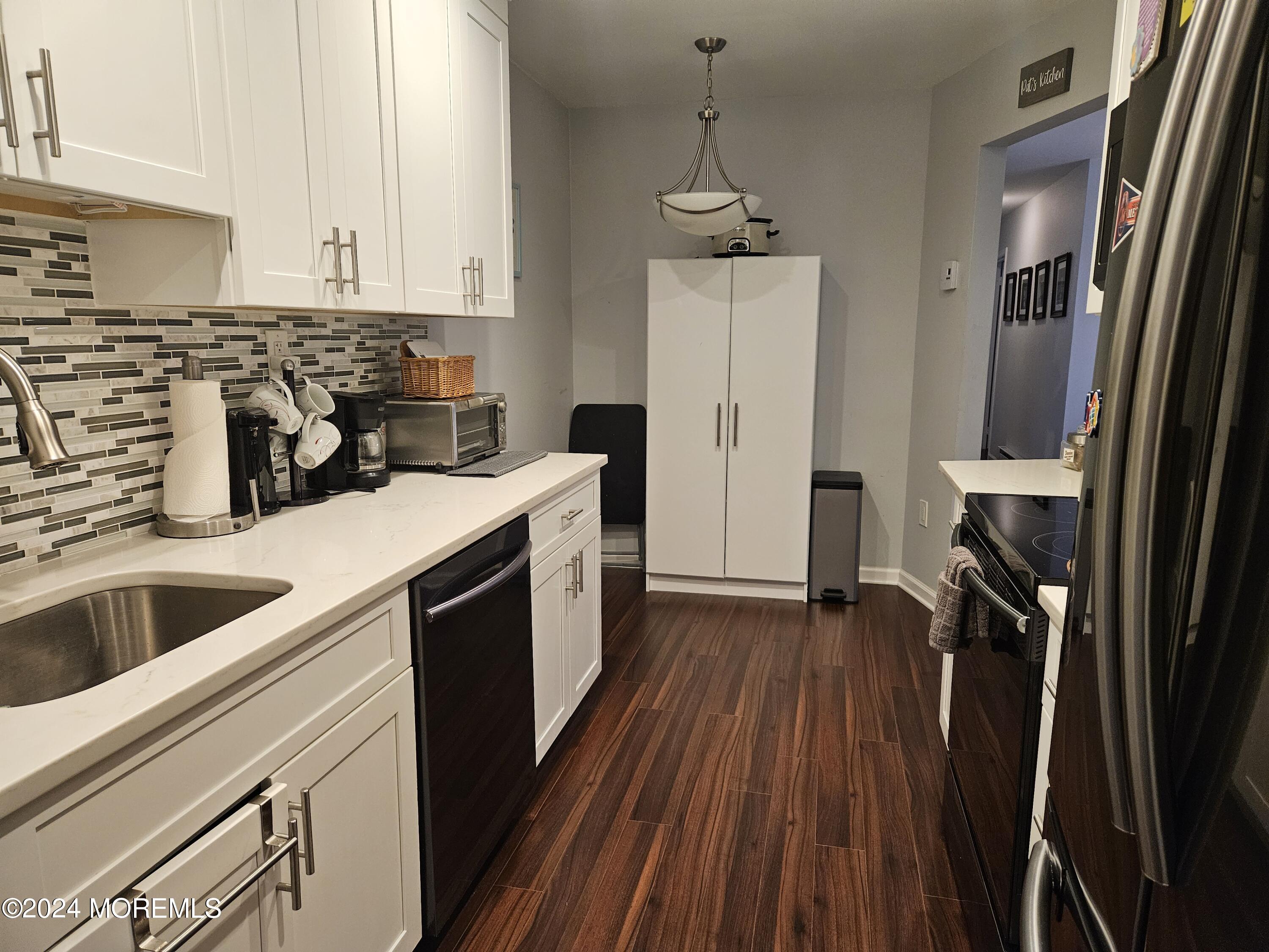75 Overlook Way, Unit E Manalapan, NJ 07726 - Photo 3 of 12 a kitchen with a sink a refrigerator a stove and cabinets