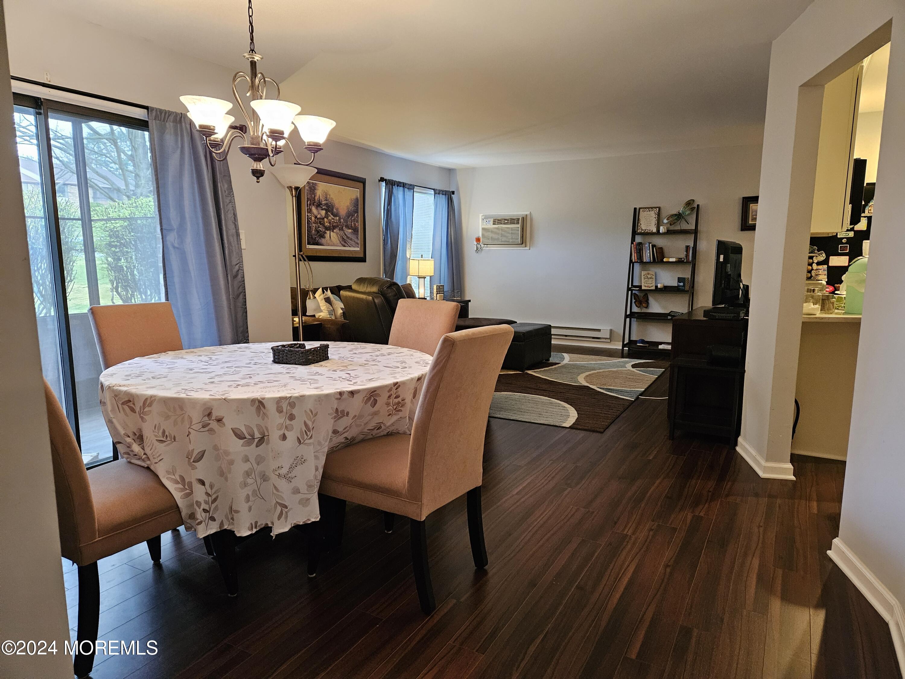 75 Overlook Way, Unit E Manalapan, NJ 07726 - Photo 5 of 12 a view of a dining room with furniture wooden floor and chandelier
