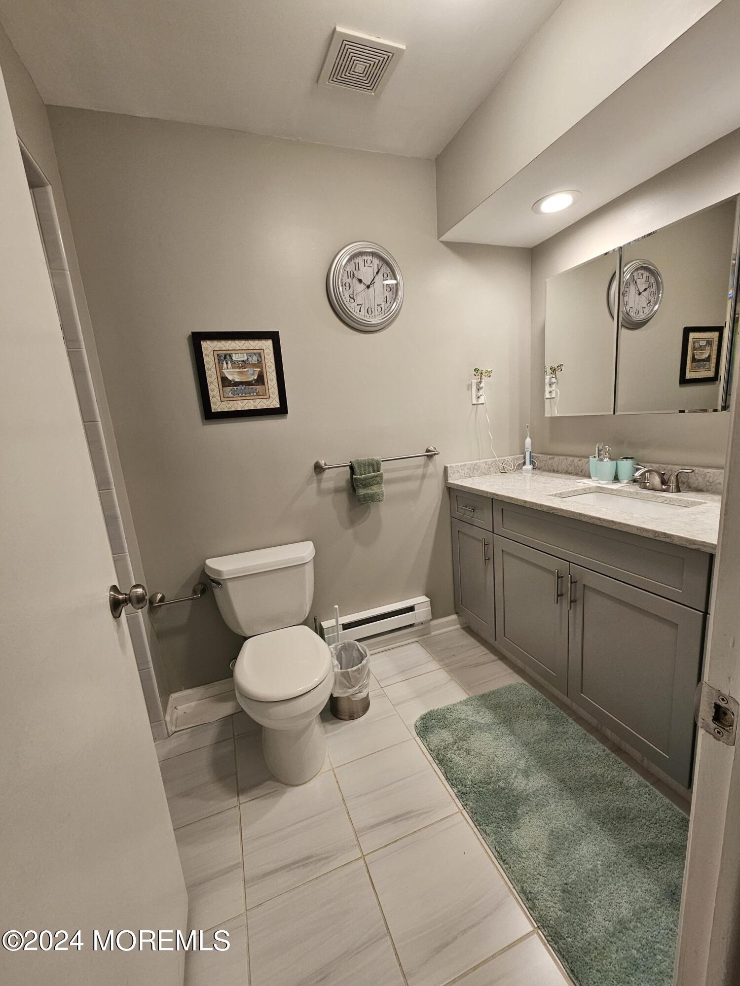 75 Overlook Way, Unit E Manalapan, NJ 07726 - Photo 10 of 12 a bathroom with a toilet sink and mirror