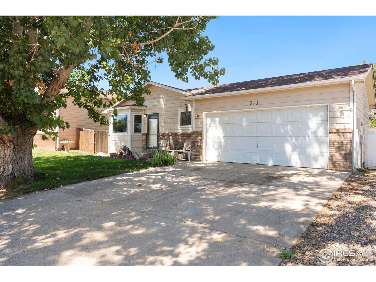 213 East 21st Street Road Greeley, CO 80631 - Photo 1 of 18 a view of a house with a yard and garage