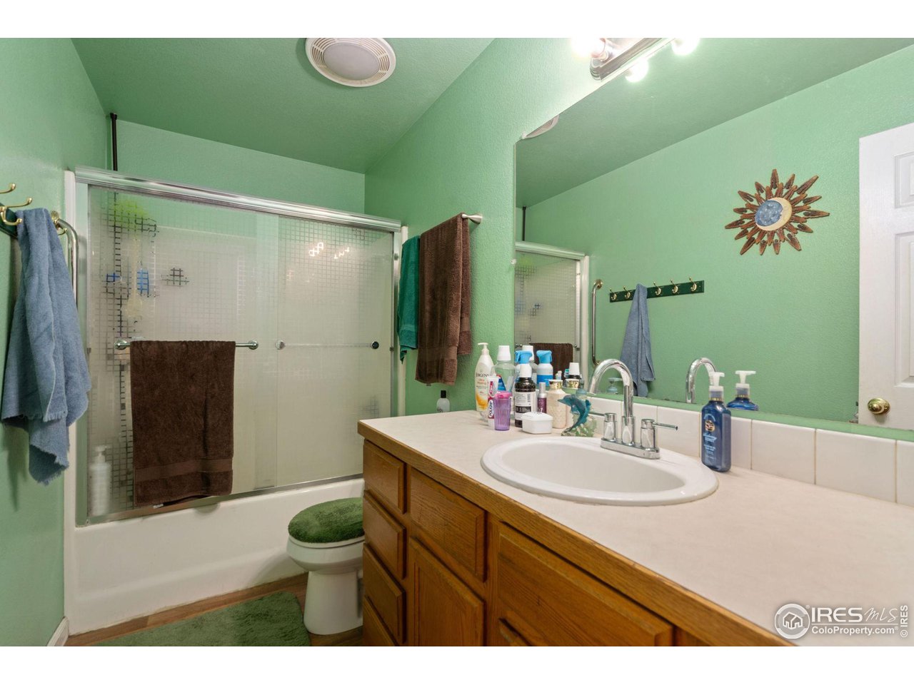 213 East 21st Street Road Greeley, CO 80631 - Photo 11 of 18 a bathroom with a sink mirror toilet and shower