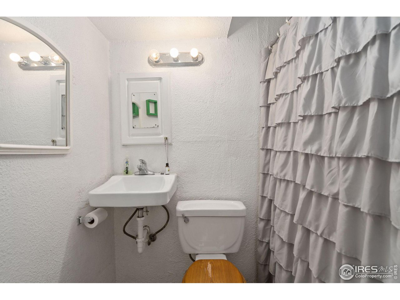 213 East 21st Street Road Greeley, CO 80631 - Photo 14 of 18 a bathroom with a sink a toilet and mirror