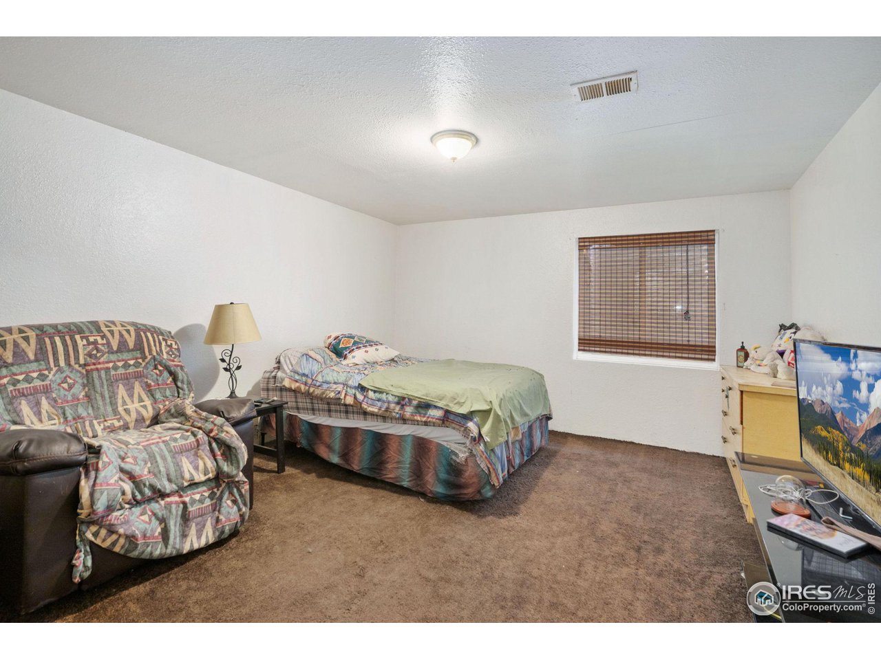 213 East 21st Street Road Greeley, CO 80631 - Photo 15 of 18 a spacious bedroom with a bed and a window
