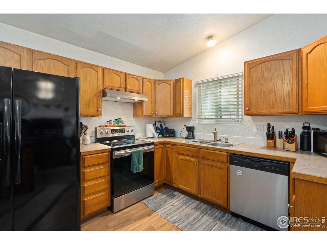 213 East 21st Street Road Greeley, CO 80631 - Photo 6 of 18 a kitchen with stainless steel appliances granite countertop a sink stove and refrigerator