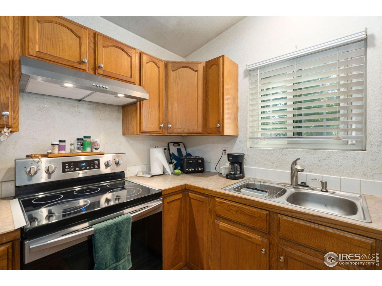 213 East 21st Street Road Greeley, CO 80631 - Photo 7 of 18 a kitchen with stainless steel appliances granite countertop a sink stove and cabinets