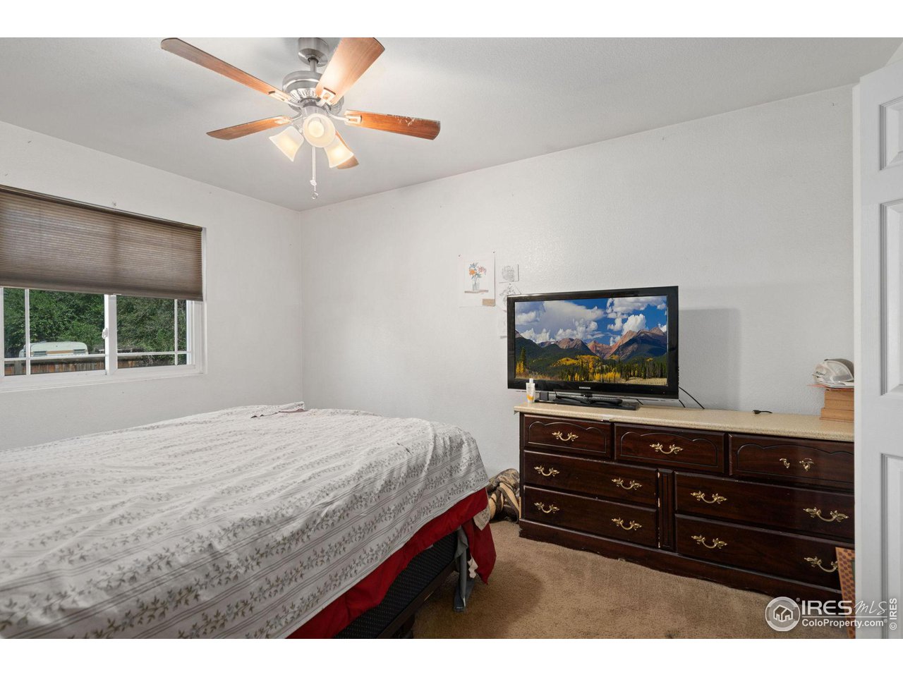 213 East 21st Street Road Greeley, CO 80631 - Photo 9 of 18 a bedroom with a bed and a flat screen tv