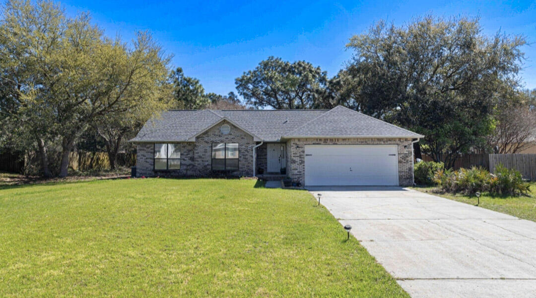 a front view of a house with yard and tree