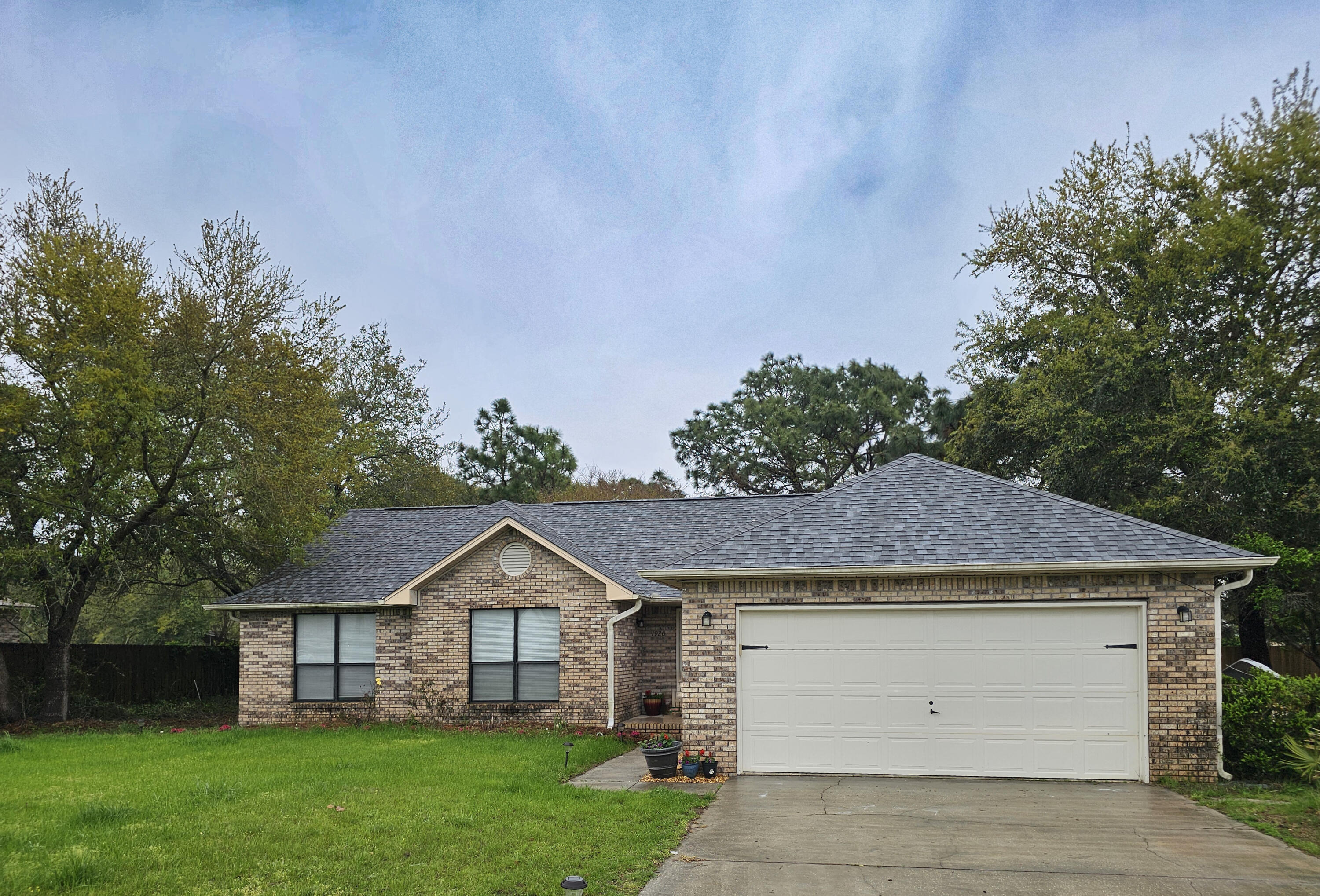 1920 Seahawk Lane Navarre, FL 32566 - Photo 2 of 30 a front view of a house with a garden and yard