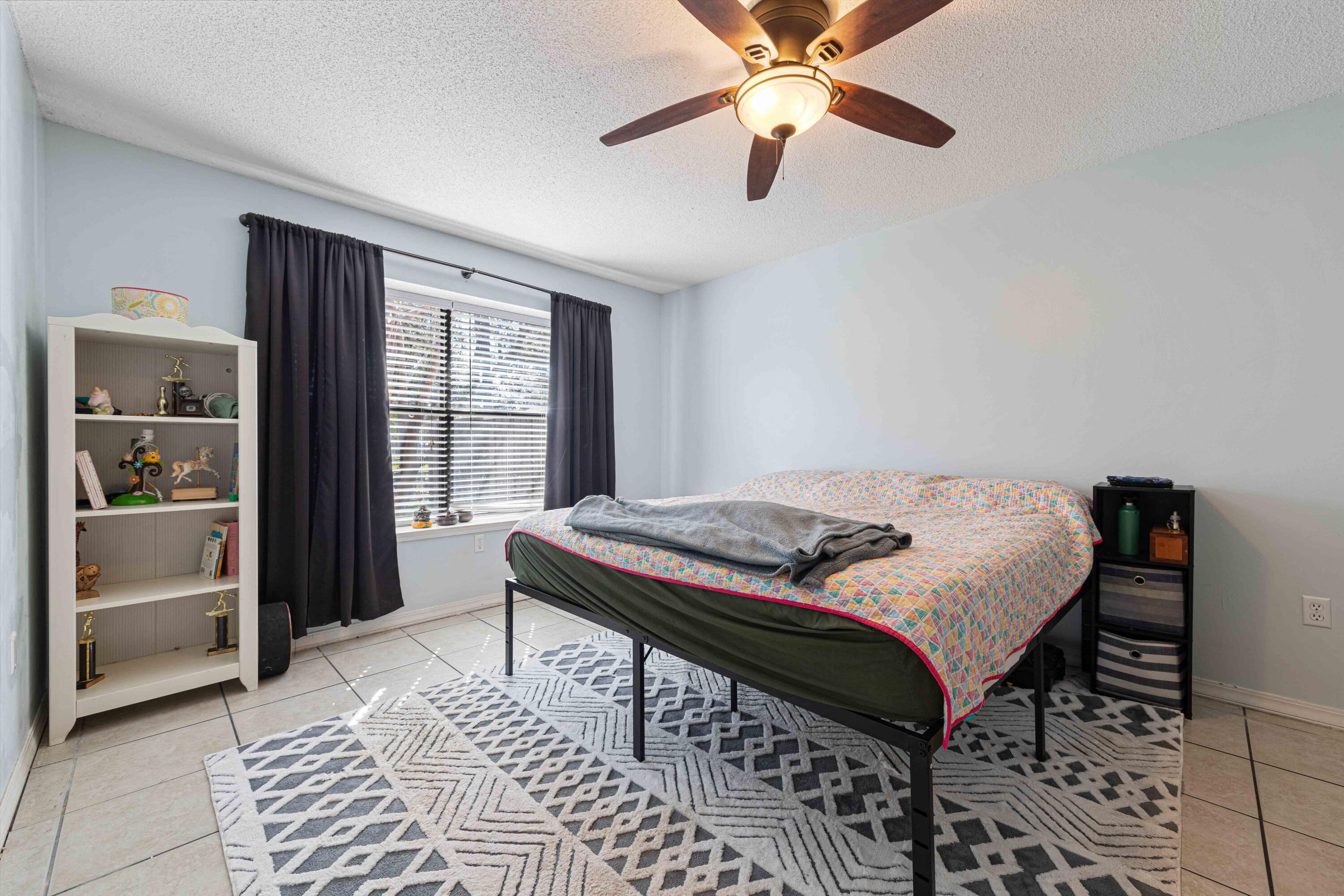 1920 Seahawk Lane Navarre, FL 32566 - Photo 21 of 30 a bedroom with a bed and a chandelier