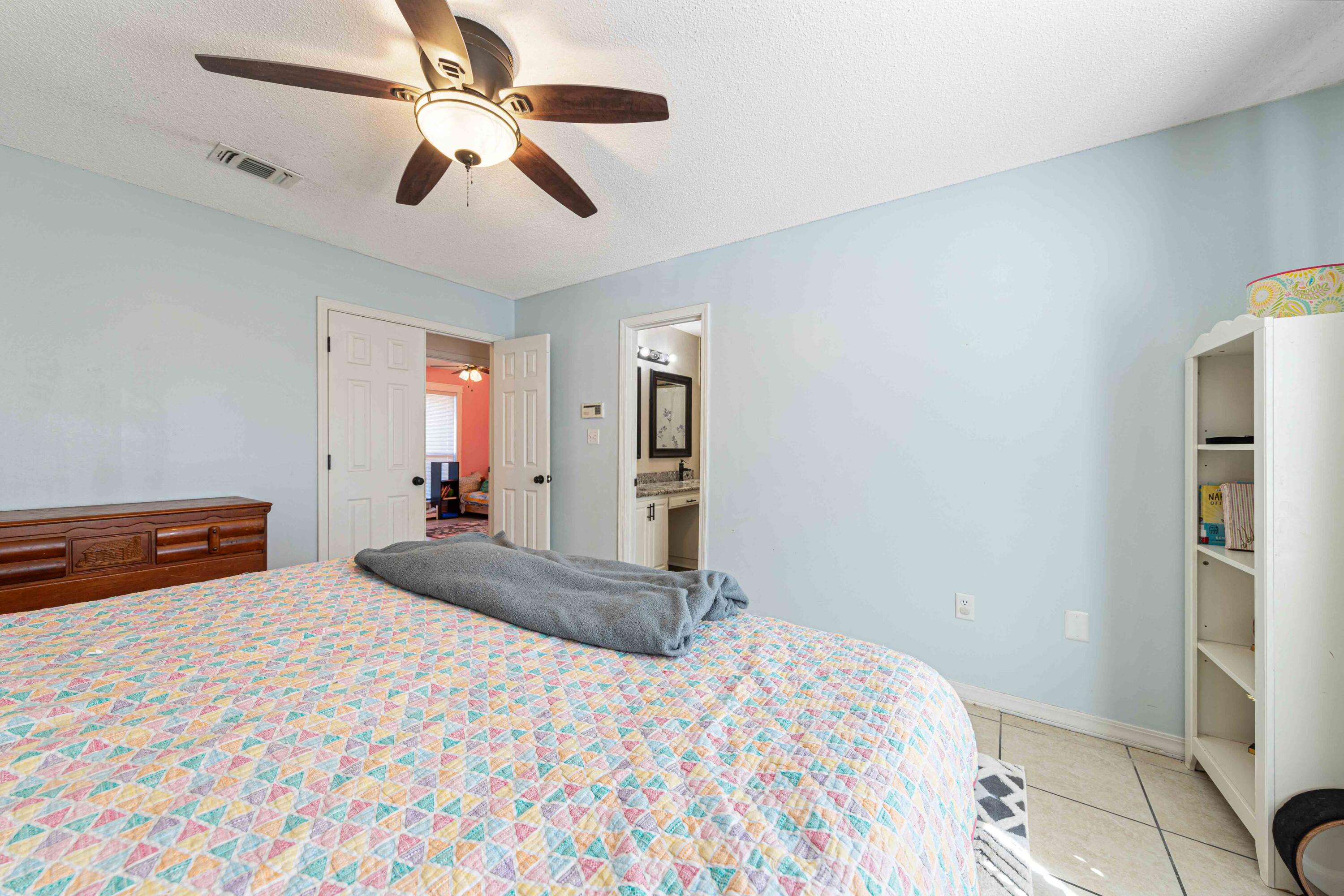 1920 Seahawk Lane Navarre, FL 32566 - Photo 22 of 30 a bedroom with a bed and a chandelier