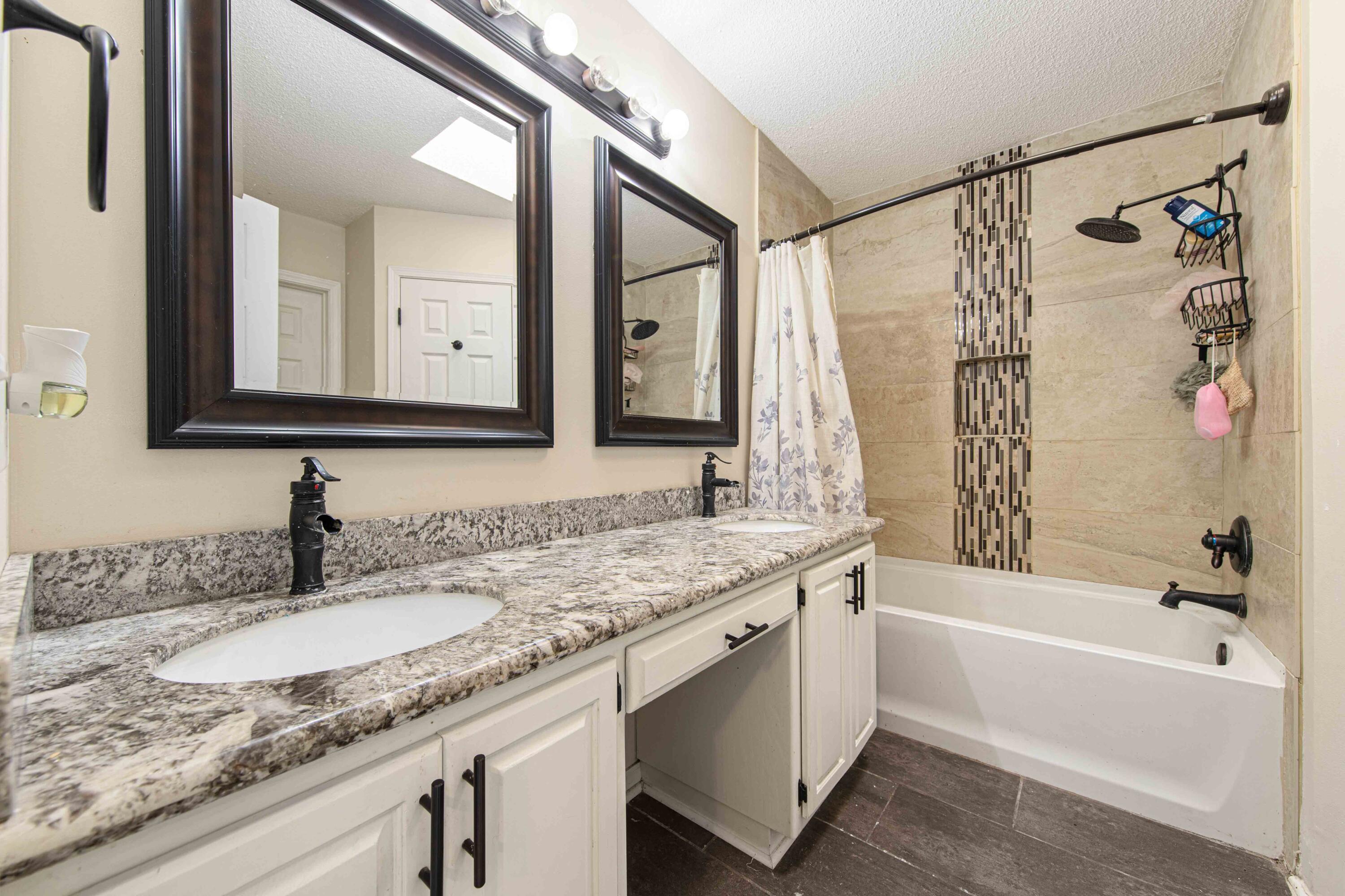 1920 Seahawk Lane Navarre, FL 32566 - Photo 23 of 30 a bathroom with a granite countertop sink mirror and a bathtub
