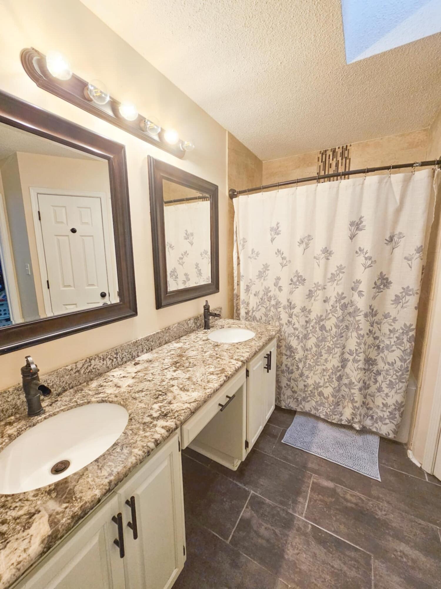 1920 Seahawk Lane Navarre, FL 32566 - Photo 25 of 30 a bathroom with a granite countertop sink a mirror a vanity and a shower