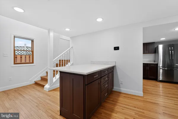 a kitchen with a sink and wooden floor