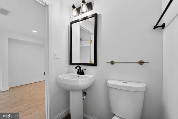 a bathroom with a toilet sink and mirror