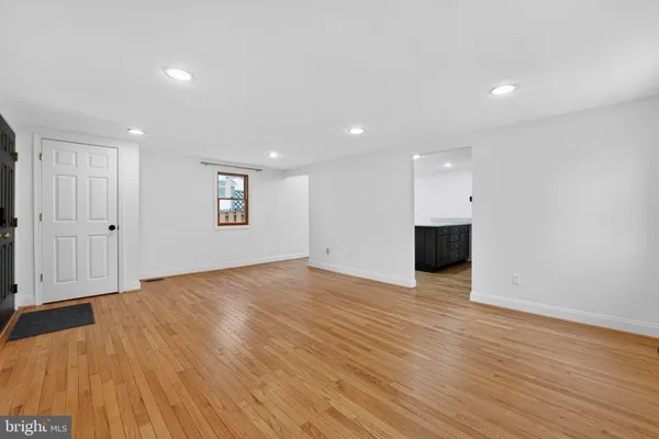 a view of empty room with wooden floor and window