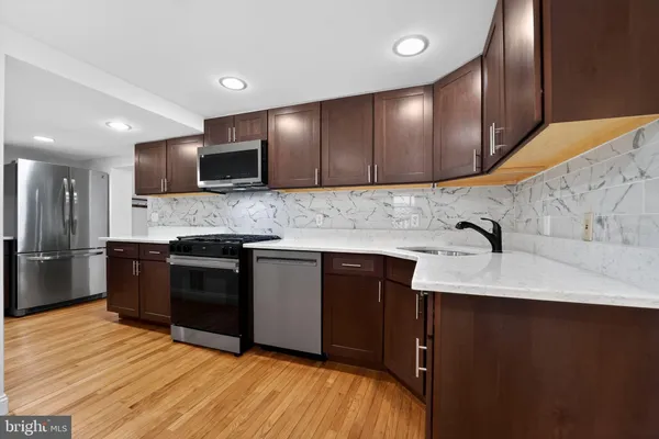 a kitchen with granite countertop stainless steel appliances and wooden cabinets