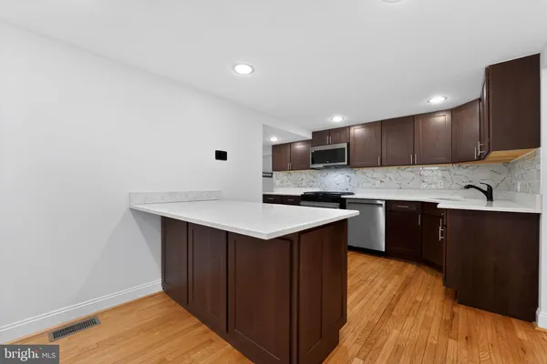 a kitchen with stainless steel appliances granite countertop a sink stove and cabinets