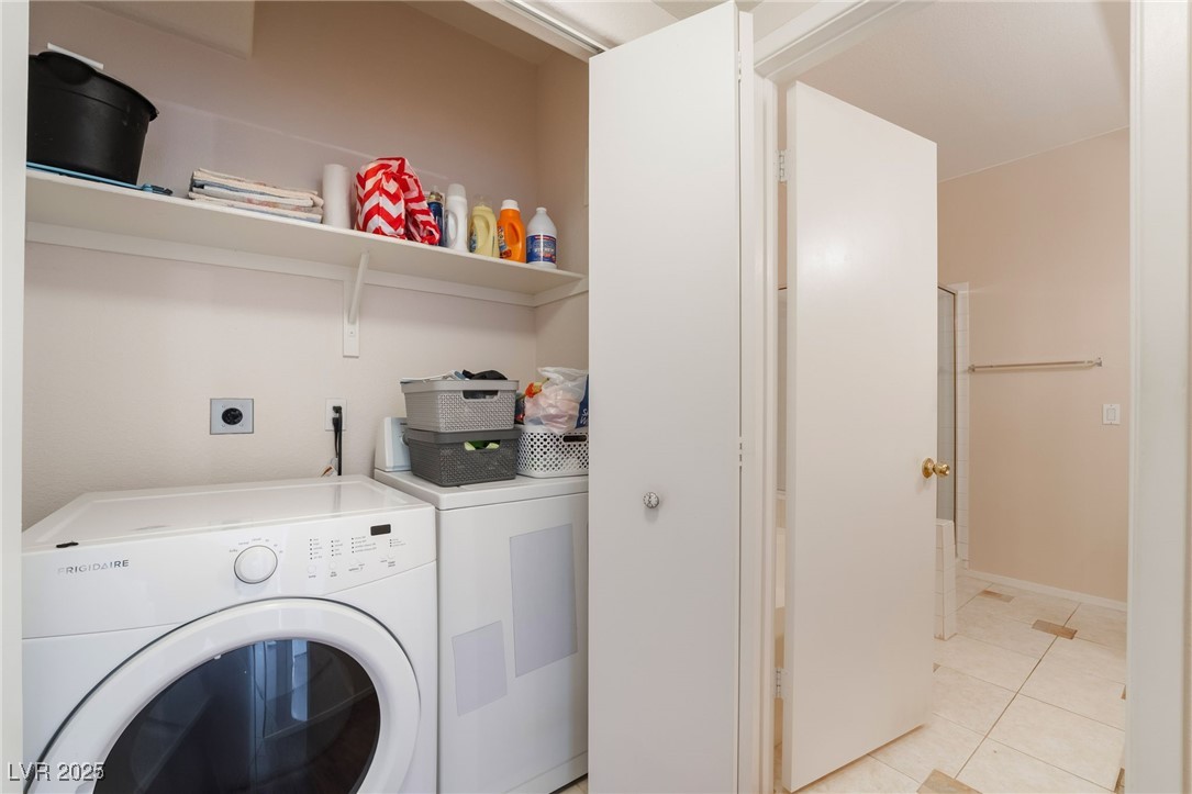 2201 Ramsgate Drive, Unit 823 Henderson, NV 89074 - Photo 25 of 31 Laundry room featuring washer and clothes dryer, laundry area, and light tile patterned flooring