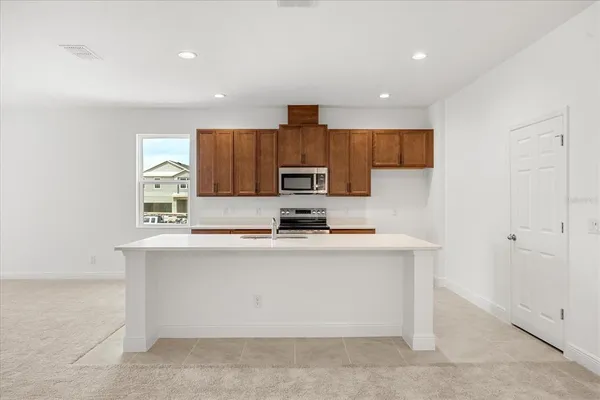 a kitchen with kitchen island a sink stainless steel appliances and cabinets