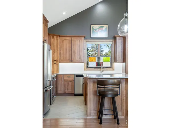 a kitchen with kitchen island granite countertop a sink cabinets and stainless steel appliances