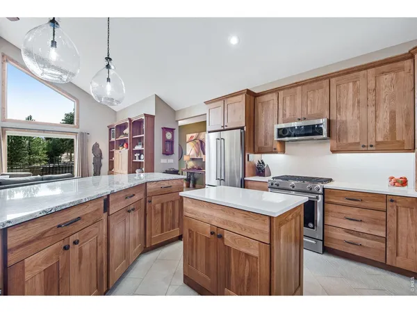 a view of kitchen island a sink a counter space and stainless steel appliances