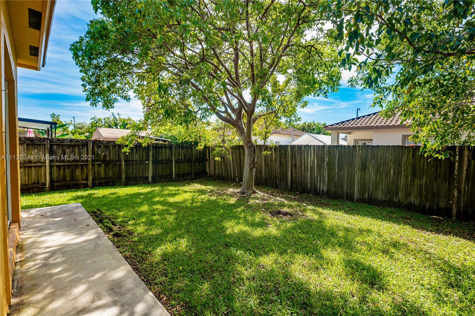 19064 Southwest 319th Street Homestead, FL 33030 - Photo 14 of 15 a view of a backyard with wooden fence and a large tree