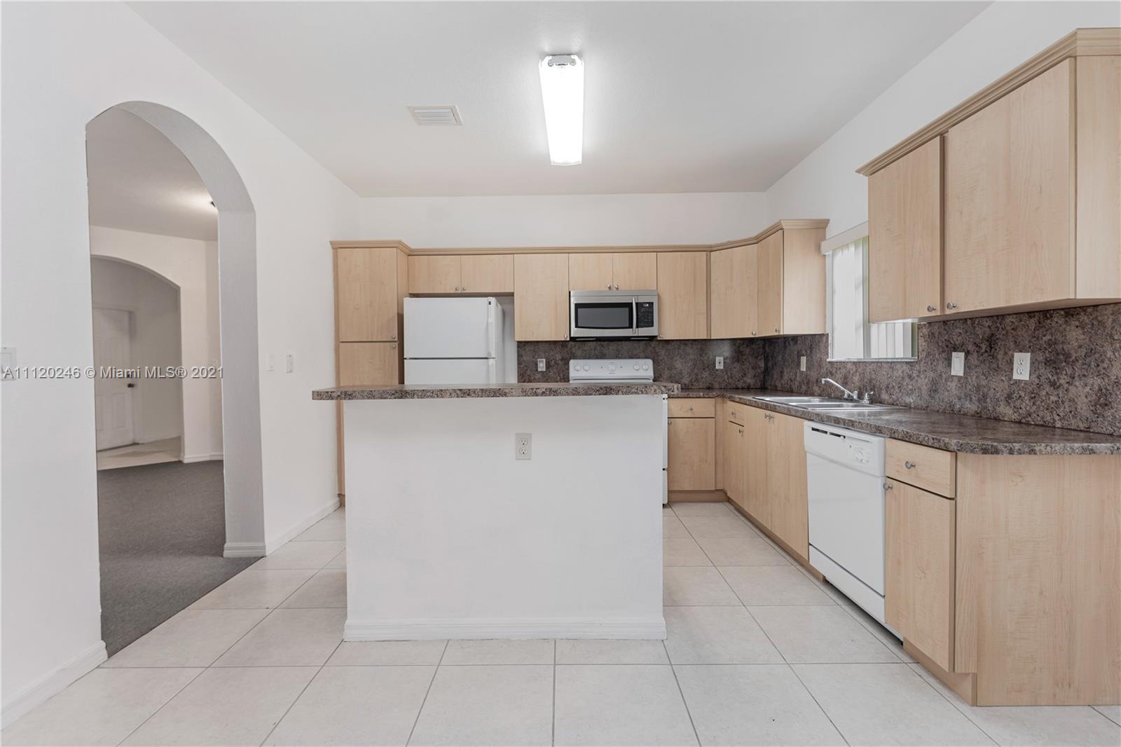 19064 Southwest 319th Street Homestead, FL 33030 - Photo 4 of 15 a kitchen with stainless steel appliances granite countertop a stove a sink and a refrigerator