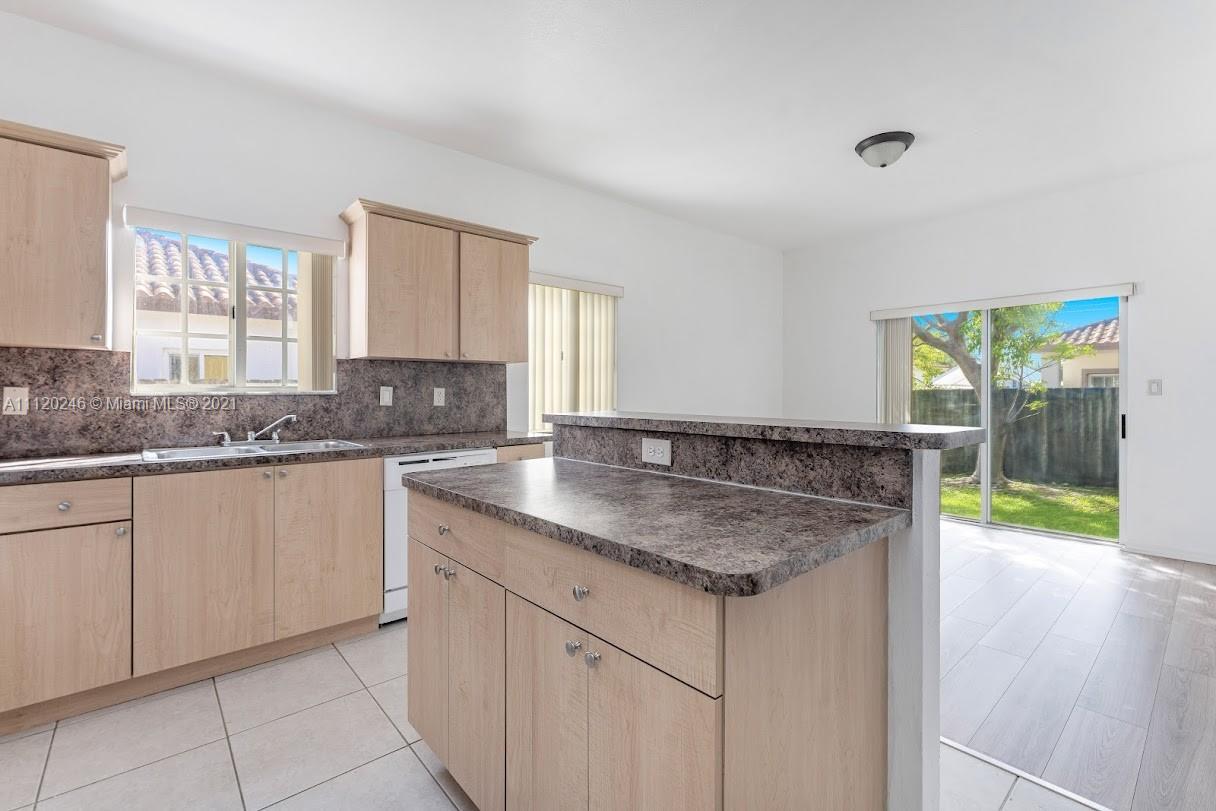 19064 Southwest 319th Street Homestead, FL 33030 - Photo 7 of 15 a kitchen with granite countertop a sink and a window