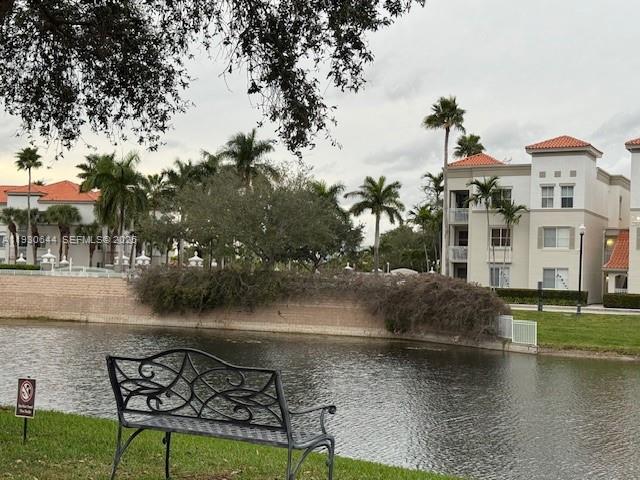 11033 Legacy Boulevard, Unit 302 Palm Beach Gardens, FL 33410 - Photo 25 of 28 a view of a lake with couches and wooden fence
