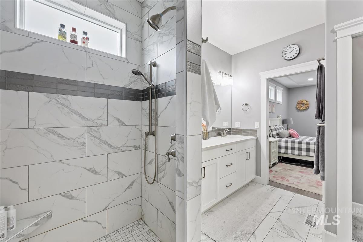 189 South Devon Avenue Star, ID 83669 - Photo 14 of 42 Full bath with light marble finish floors, vanity, a marble finish shower, and connected bathroom