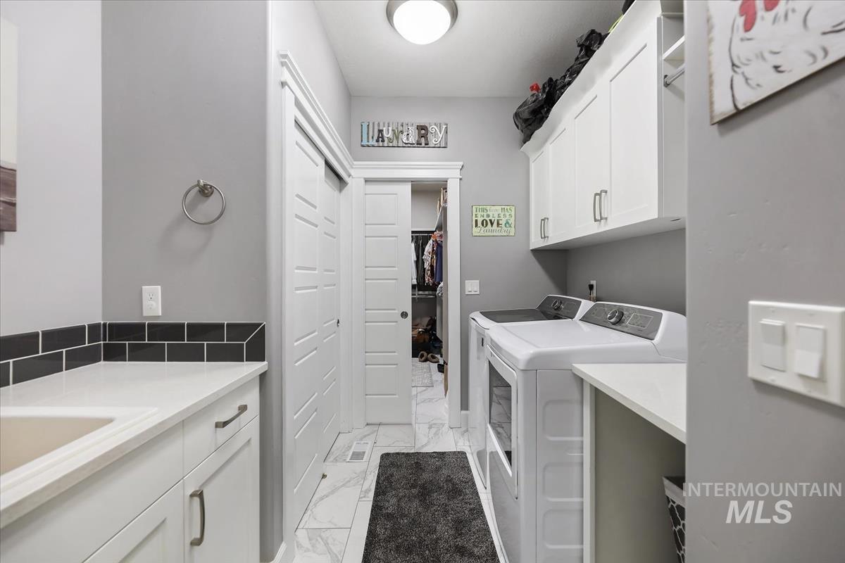 189 South Devon Avenue Star, ID 83669 - Photo 17 of 42 Laundry room featuring light marble finish floors, cabinet space, and washing machine and clothes dryer