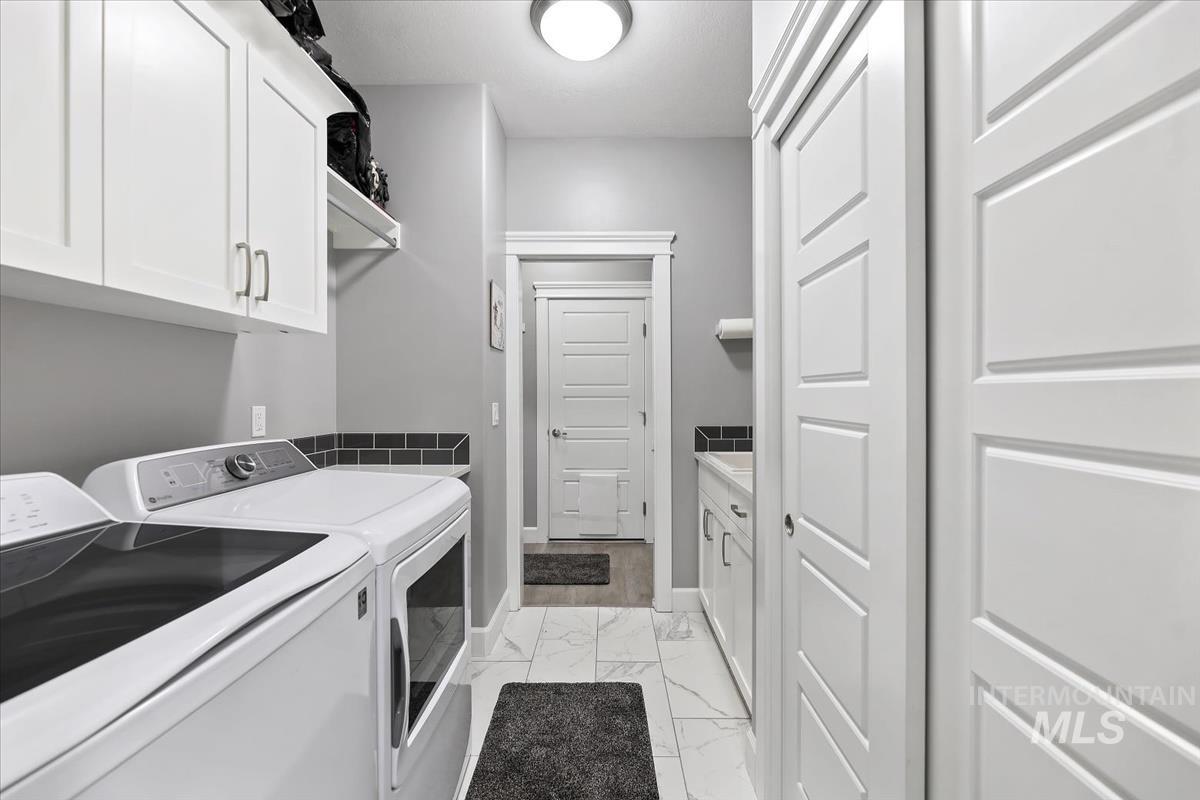 189 South Devon Avenue Star, ID 83669 - Photo 18 of 42 Laundry area with light marble finish flooring, cabinet space, and washer and clothes dryer