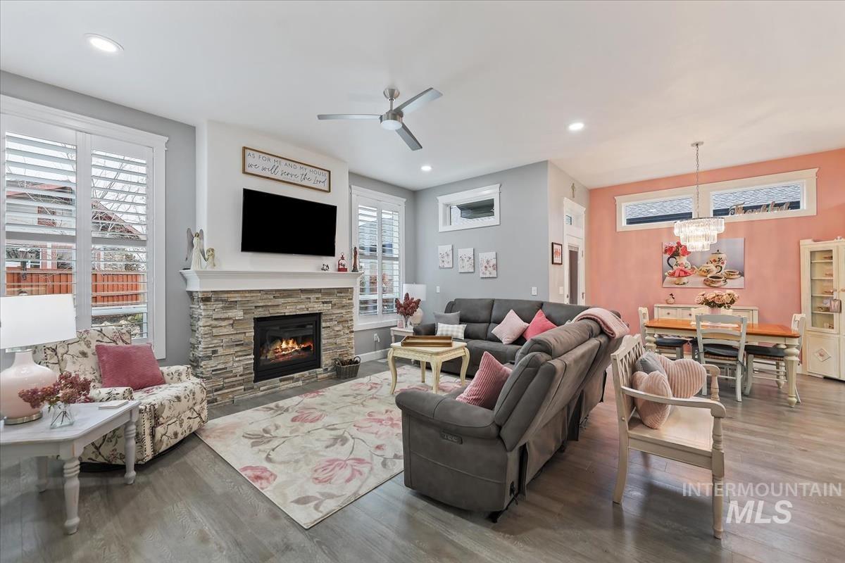189 South Devon Avenue Star, ID 83669 - Photo 20 of 42 Living room featuring ceiling fan, wood finished floors, recessed lighting, a chandelier, and a stone fireplace