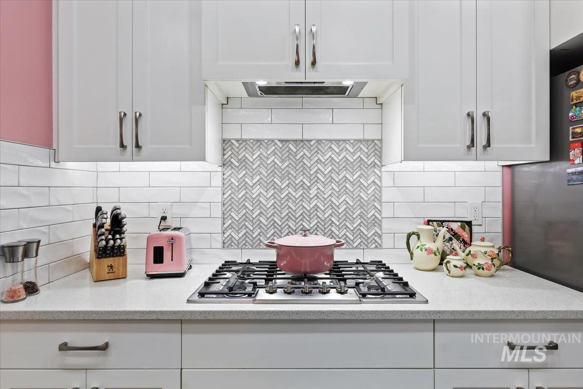189 South Devon Avenue Star, ID 83669 - Photo 2 of 42 Kitchen with white cabinets, stainless steel appliances, light stone counters, and backsplash