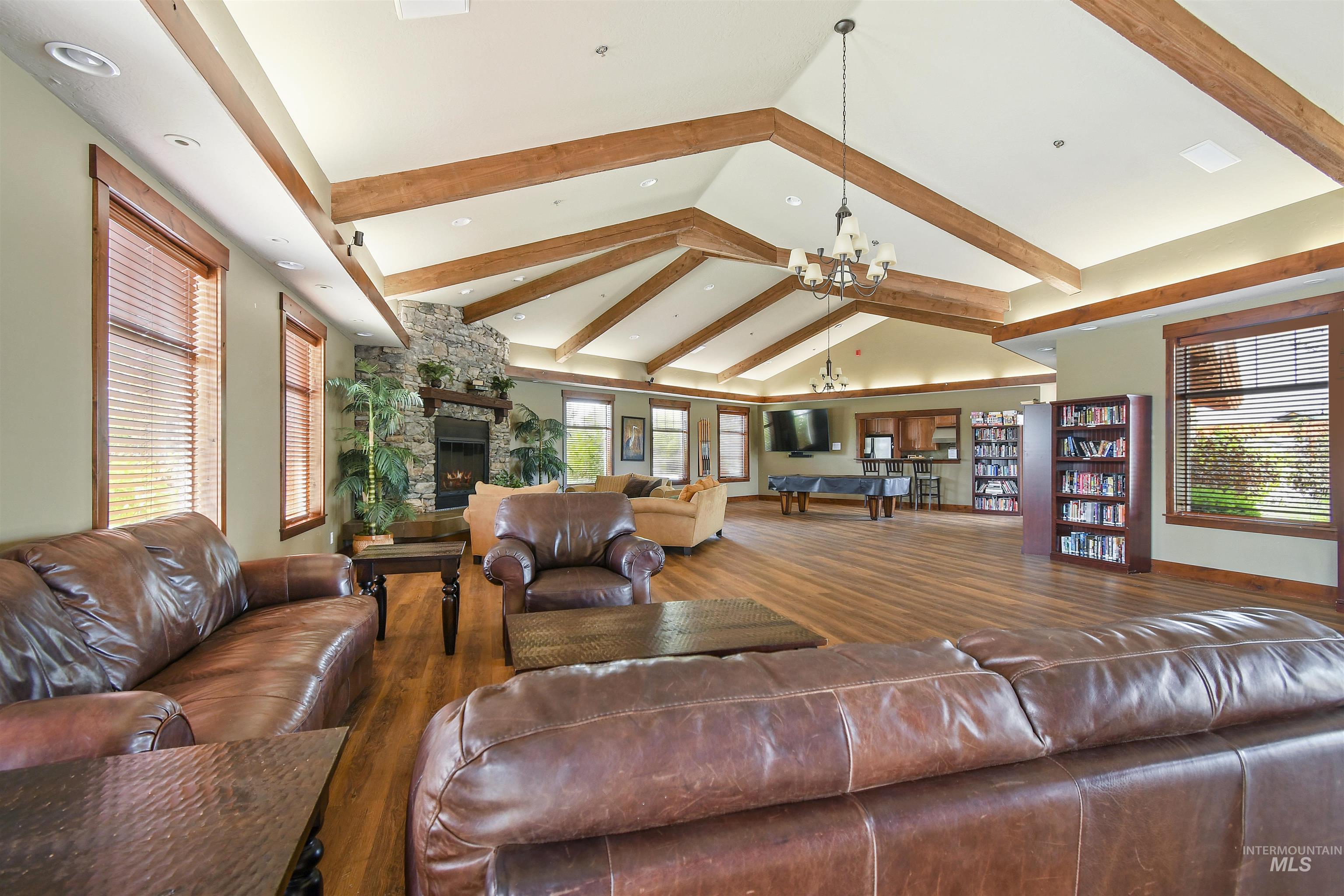 189 South Devon Avenue Star, ID 83669 - Photo 37 of 42 Living room featuring high vaulted ceiling, a stone fireplace, wood finished floors, a chandelier, and beam ceiling