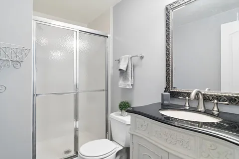 a bathroom with a granite countertop sink toilet and shower