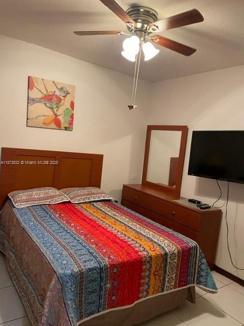 14188 Southwest 145th Place, Unit 1 Miami, FL 33186 - Photo 3 of 6 a bedroom with a bed and a chandelier