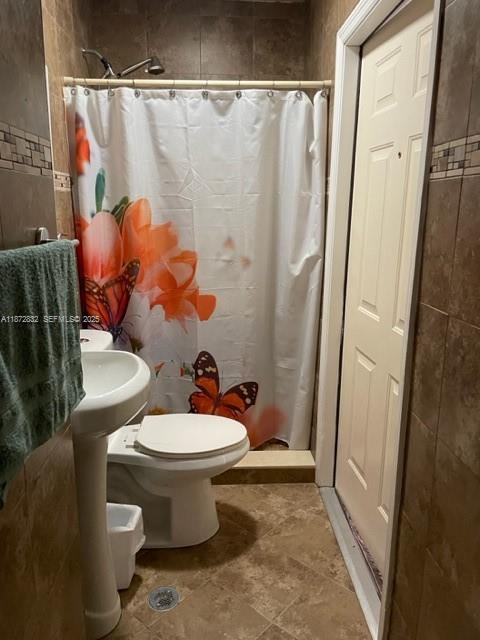 14188 Southwest 145th Place, Unit 1 Miami, FL 33186 - Photo 5 of 6 a white toilet sitting next to a shower curtain