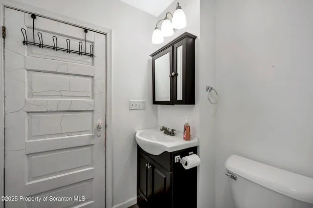 a bathroom with a sink a light fixture and a toilet