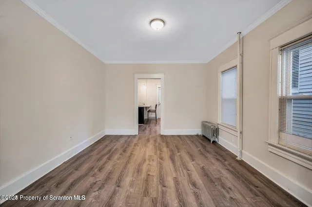 wooden floor in an empty room with a window