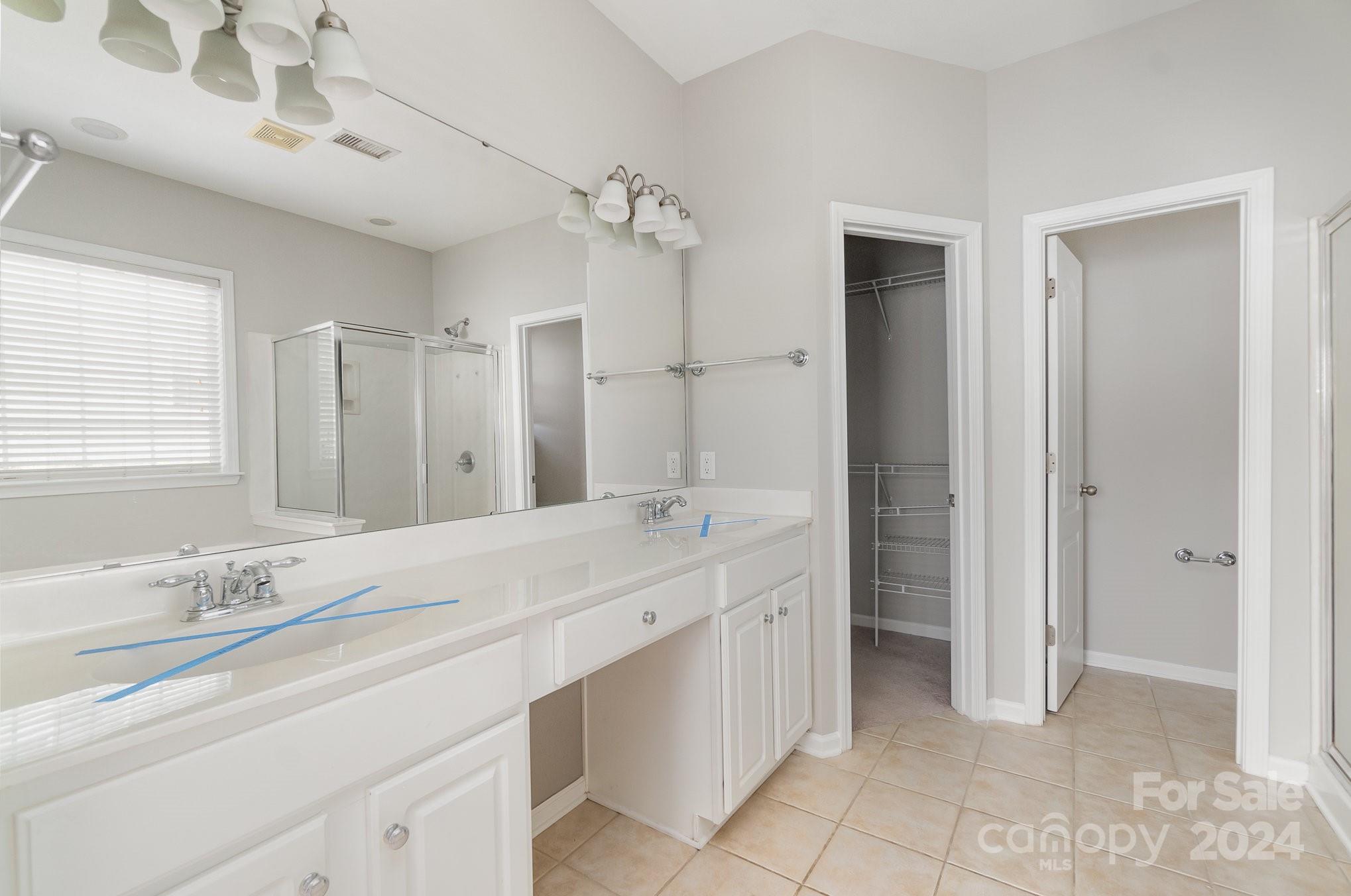 2532 Coltsgate Road Waxhaw, NC 28173 - Photo 11 of 21 a bathroom with a double vanity sink a mirror and a bathtub