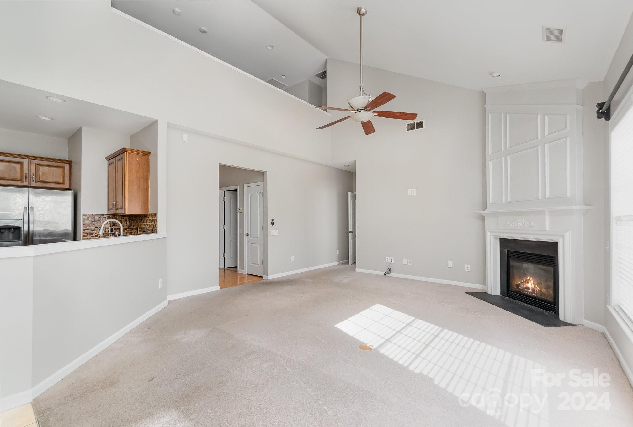 2532 Coltsgate Road Waxhaw, NC 28173 - Photo 8 of 21 a view of a livingroom with a fireplace a ceiling fan and a window