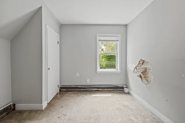 an empty room with closet and mirror
