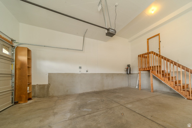 598 Hollow Creek Road Draper, UT 84020 - Photo 108 of 110 Spacious garage with a concrete floor, white painted walls, exposed ceiling joists, and an automatic garage door opener