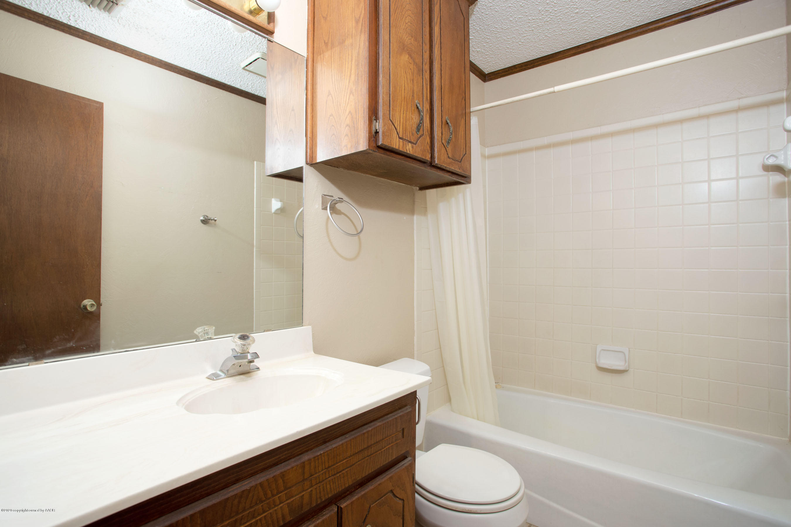 8213 Wrangler Trail Amarillo, TX 79110 - Photo 16 of 20 a bathroom with a sink a toilet a mirror and shower